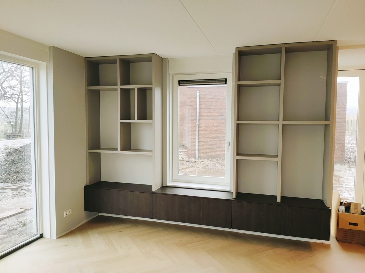 Wandkast op maat met open vakken in grijs en een donker houten ladeblok