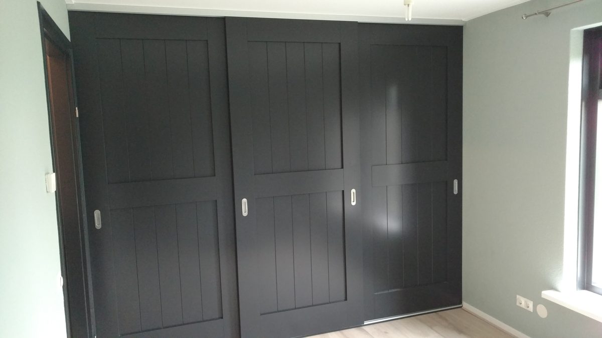 Kastenwand met drie zwarte schuifdeuren op maat